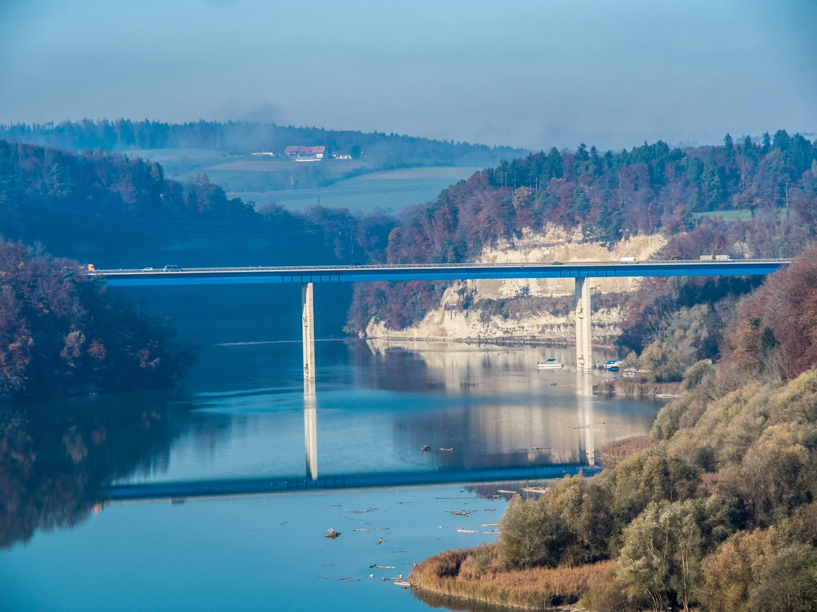 Moderne Brücke über den ruhigen Schiffenensee mit Waldlandschaft im Hintergrund.