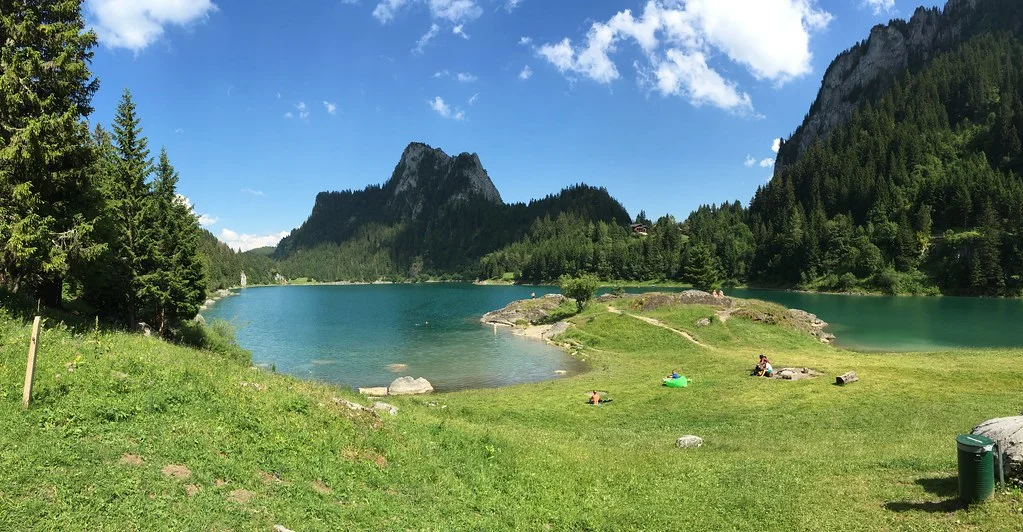 Lac de Tanay: malerischer Bergsee in den Alpen mit grünen Ufern und bewaldeten Bergen.