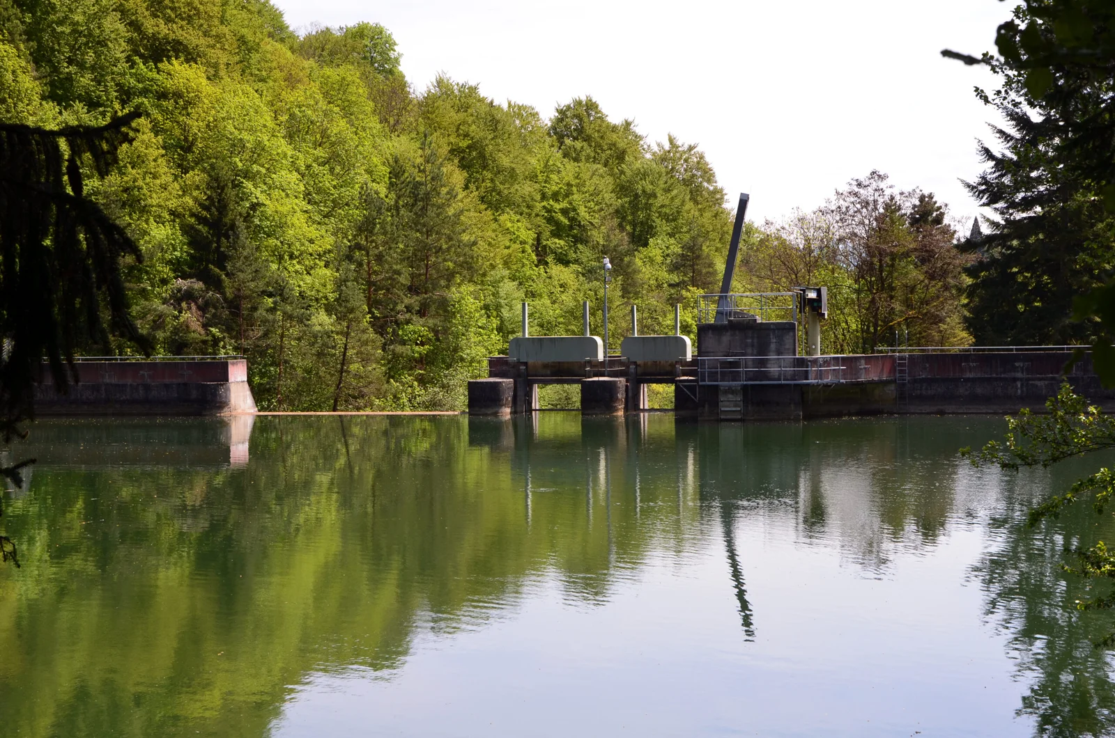 Lac des Vaux: Stausee mit Schleusenanlage und grüner Ufervegetation.