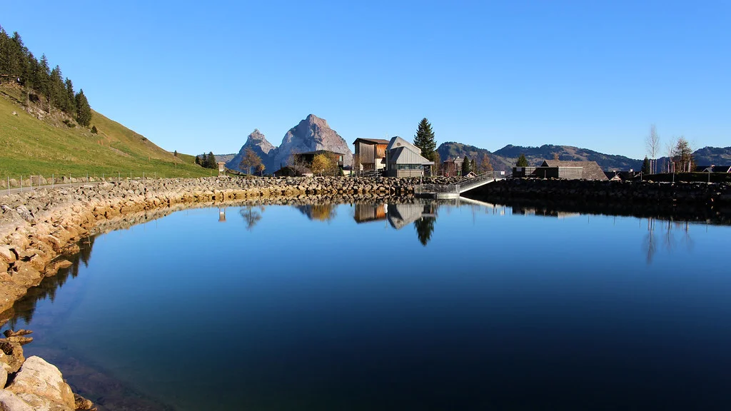 Stoos Seeli See mit Spiegelung der Berge und Häuser im klaren Wasser.