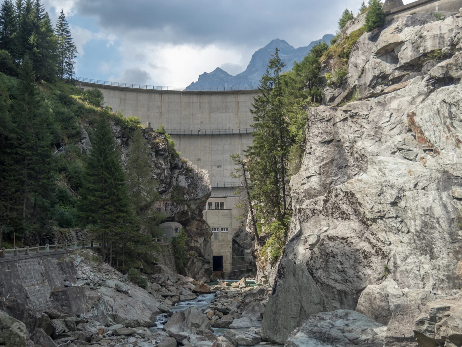 Sufnersee Staumauer mit Felsen und Bäumen. Kraftwerk im Tal.
