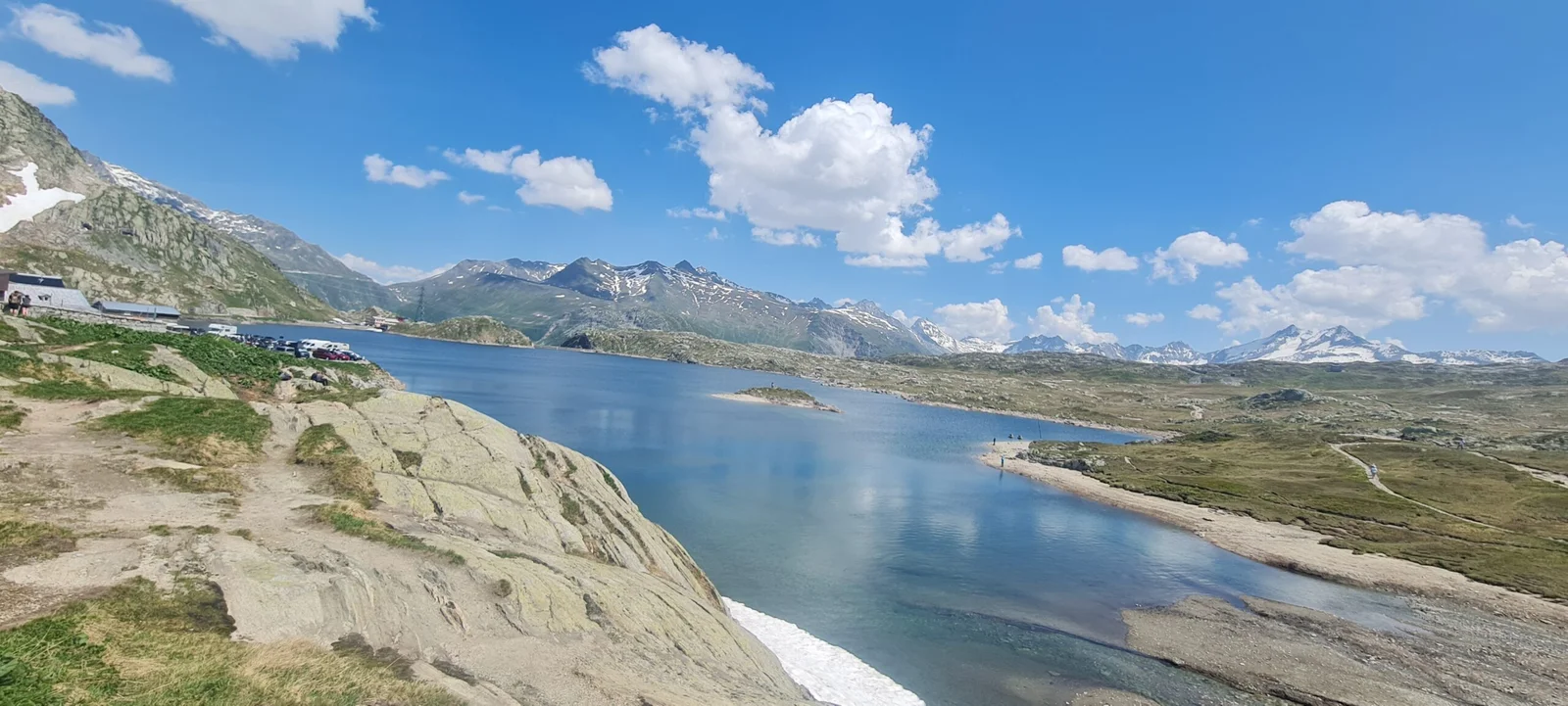 Totensee in den Schweizer Alpen: Bergsee mit schneebedeckten Gipfeln unter blauem Himmel.